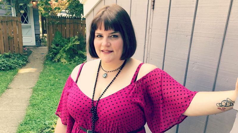 Eine fette Mutter in einem rosa Kleid mit schwarzen Punkten steht im Hinterhof und hat gelernt, wie man ...