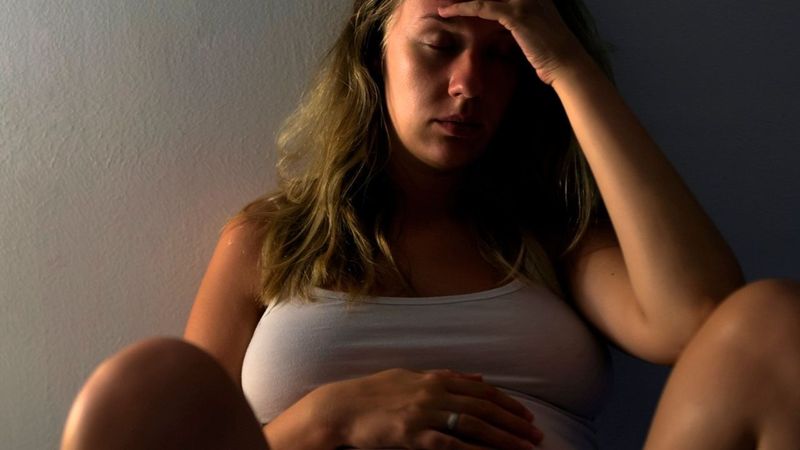 Frau berührt ihren schwangeren Bauch
